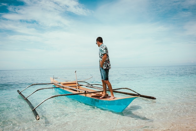 Barco tradicional filipino en una playa blanca en el mar