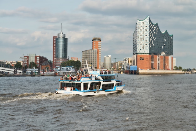 Barco con turistas va en el río Elba hacia Elbphilharmonie en Hamburgo