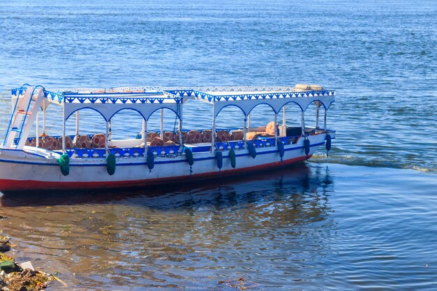 Barco turístico amarrado cerca de la orilla del río Nilo en Luxor Egipto