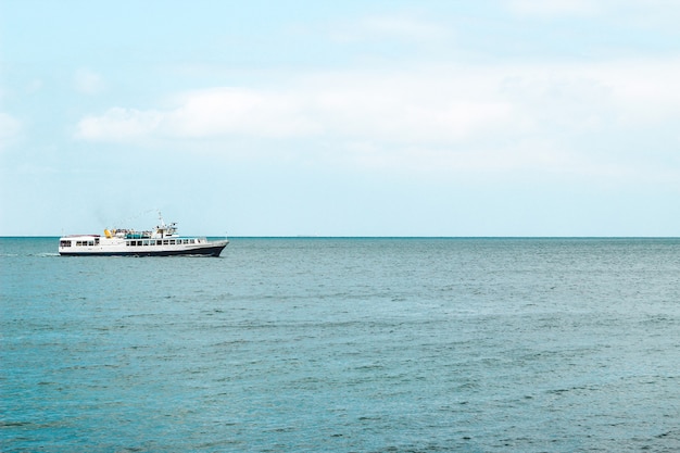 Barco turístico navegando aqui no mar azul.