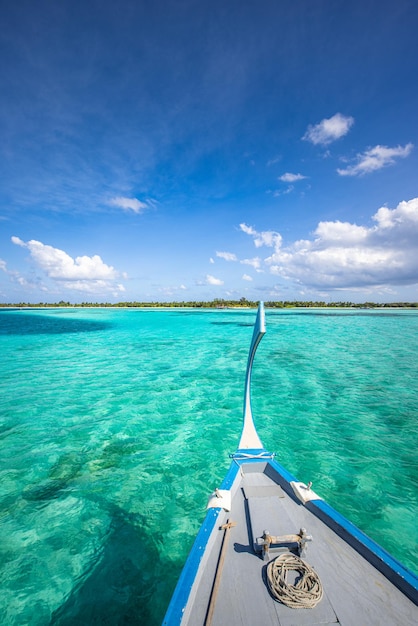 Barco de vela de madera en una laguna tropical cristalina cerca de la playa. Aventura en Maldivas