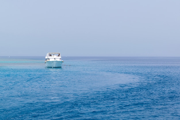 Barco de vela en el mar azul, paisaje de barco en mar abierto tranquilo.