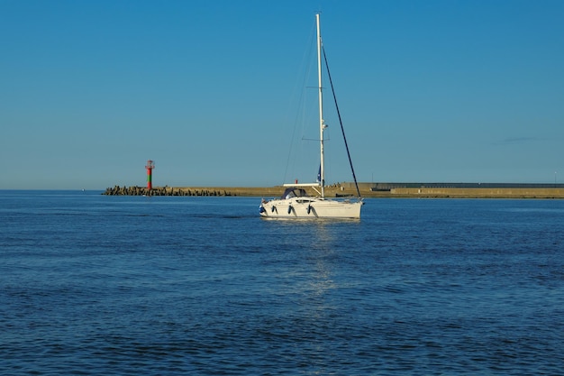 Barco de vela en el mar contra el telón de fondo de las montañas barco navegando en el mar