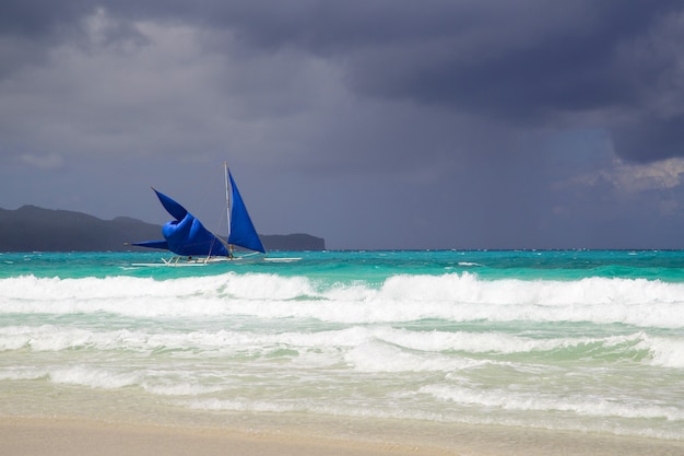 Barco de vela en el mar en la isla de Boracay antes de la tormenta, Filipinas