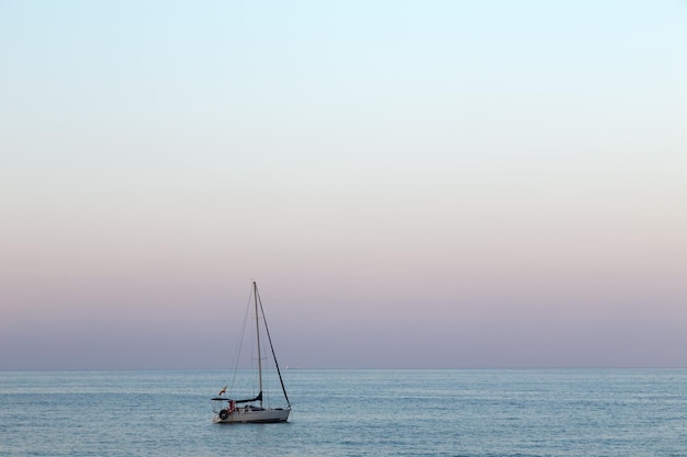 barco velero anclado al atardecer, yate en el mar