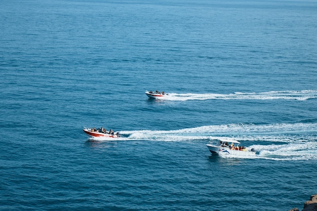 Barcos a motor com passageiros no mar, um passeio pelo mar, rochas e montanhas