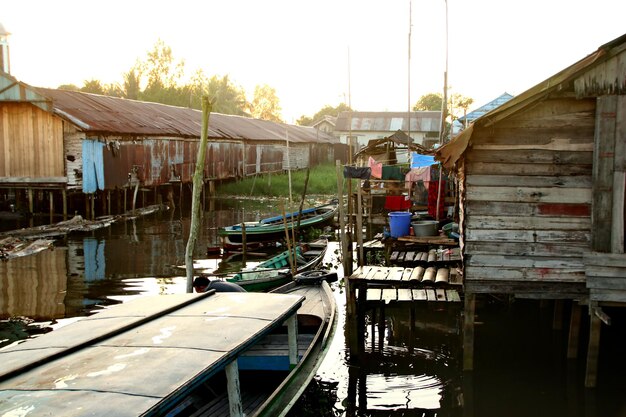 Barcos a vela ancorados no canal por casas contra o céu