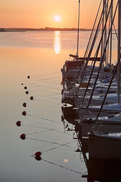 Barcos a vela ancorados no mar contra o céu durante o pôr-do-sol