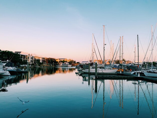 Foto barcos a vela ancorados no porto ao pôr-do-sol