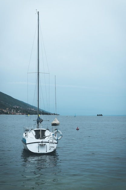 Barcos a vela e cenário sombrio de Itália de água azul clara