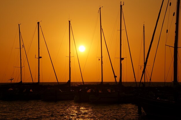 Barcos a vela no mar ao pôr-do-sol