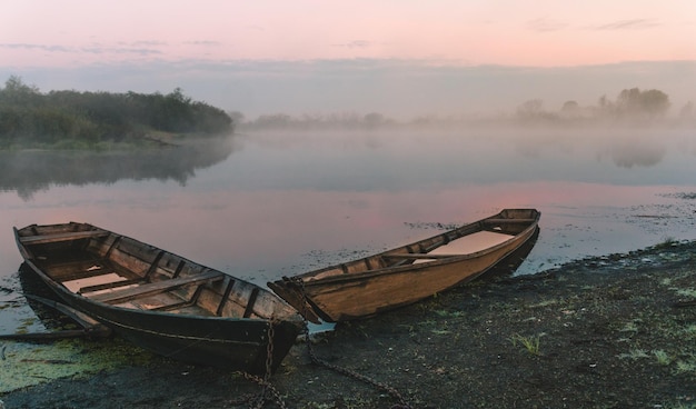 Barcos afundados no nevoeiro da costa Amanhecer da paisagem no rio Pripyat