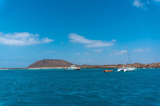 Barcos en aguas turquesas en la Isla de Lobos frente a la costa norte de Fuerteventura