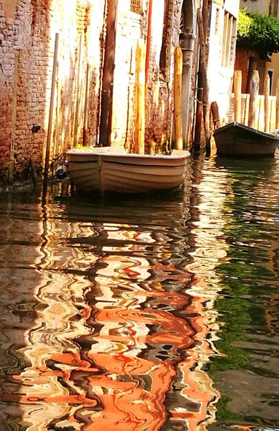 Foto barcos amarrados en el canal por los edificios de la ciudad