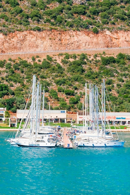 Barcos amarrados cerca de una costa rocosa a la luz del sol