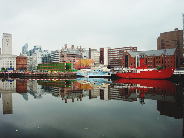 Foto barcos amarrados en el muelle con la ciudad en el fondo