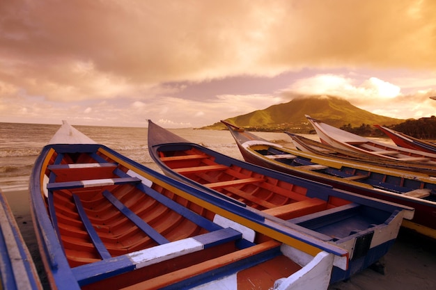 Barcos amarrados en la playa contra el cielo durante la puesta de sol