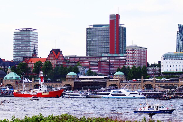 Foto barcos amarrados en el río contra edificios en la ciudad