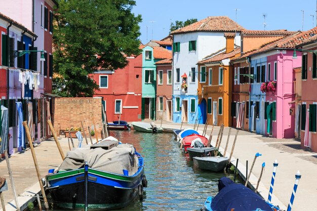 Barcos ancorados em um canal perto de edifícios coloridos na ilha de Burano