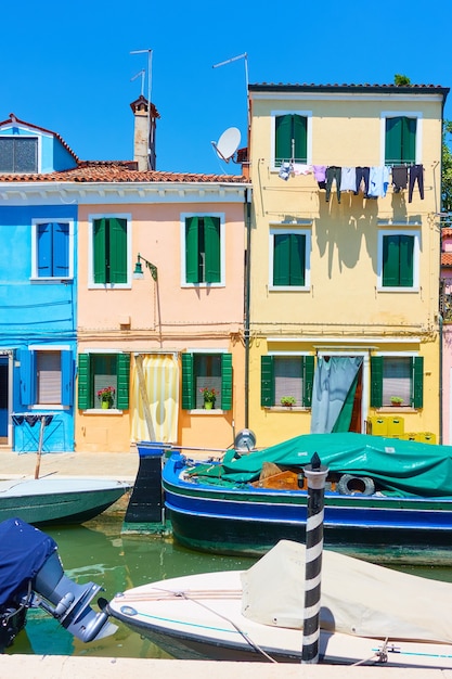 Barcos y casas de colores por canal en la isla de Burano en Venecia, Italia - paisaje urbano italiano