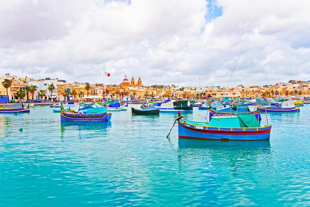 Barcos coloridos de Luzzu en el puerto de Marsaxlokk en la bahía del mar Mediterráneo, isla de Malta