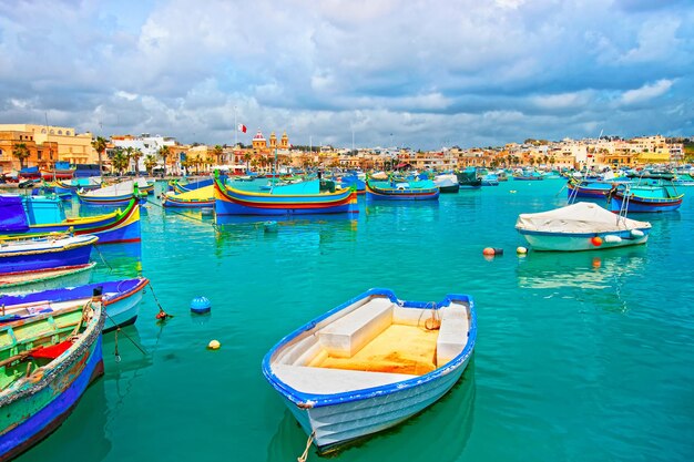 Barcos coloridos de Luzzu en el puerto de Marsaxlokk de la bahía del mar Mediterráneo, isla de Malta