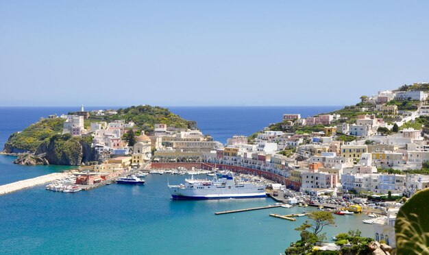 Barcos de balsa ancorados no porto pela cidade em Ponza contra um céu claro