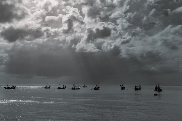 Barcos de cauda longa de pescadores tradicionais tailandeses sob céu nublado com raios solares Koh Samui Tailândia
