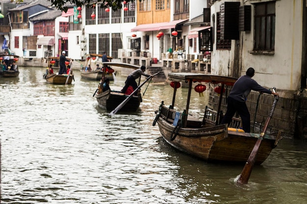 Barcos de madeira chineses com lanternas vermelhas estacionados em um dos canais na antiga cidade de Zhujiajiao