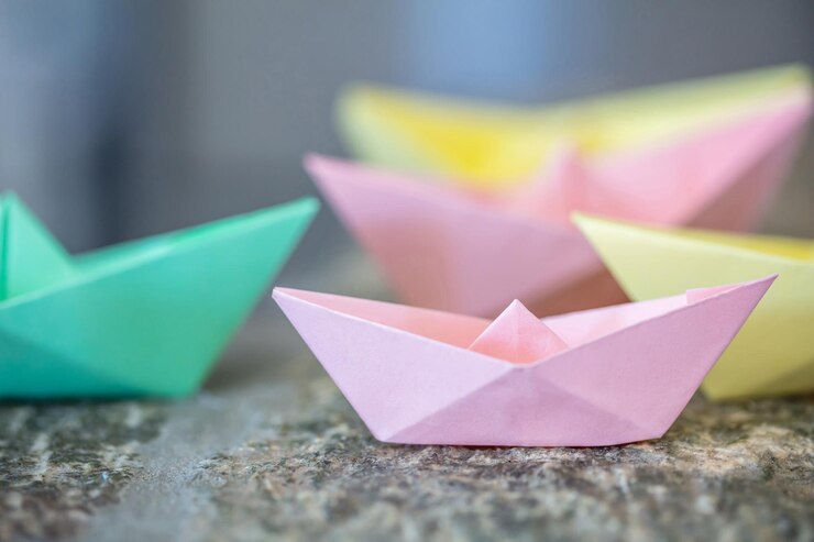 Foto barcos de origami dobrados em papel em uma rocha
