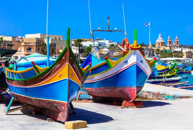 Foto barcos de pesca coloridos tradicionais luzzu em malta - vila marsaxlokk