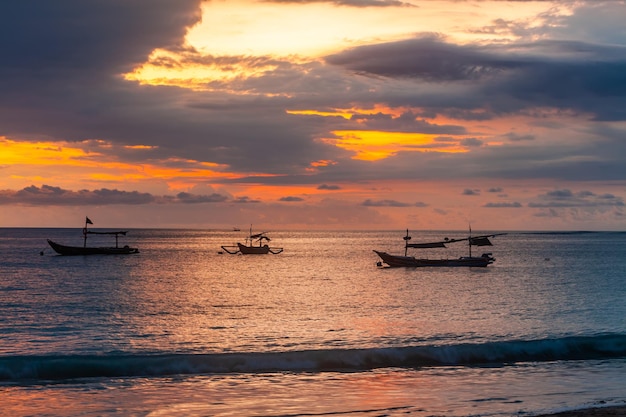 Barcos de pesca de Bali Indonésia ao pôr do sol Paisagem de viagem