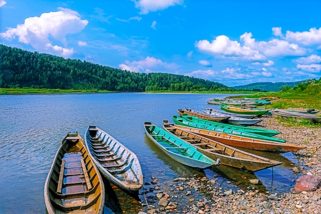 Barcos de pesca de madeira atracados na margem do rio