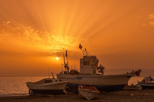 Barcos de pesca na costa ao pôr-do-sol