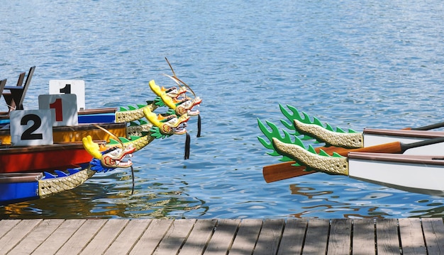 Barcos dragón amarrados en un embarcadero de madera