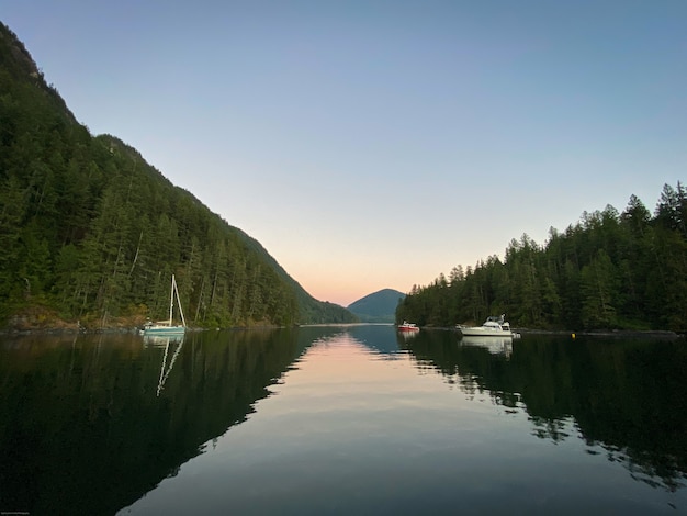 Barcos em ancoradouro calmo ao pôr do sol na Colúmbia Britânica no Canadá