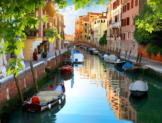 Barcos em estreito canal veneziano de água, Itália