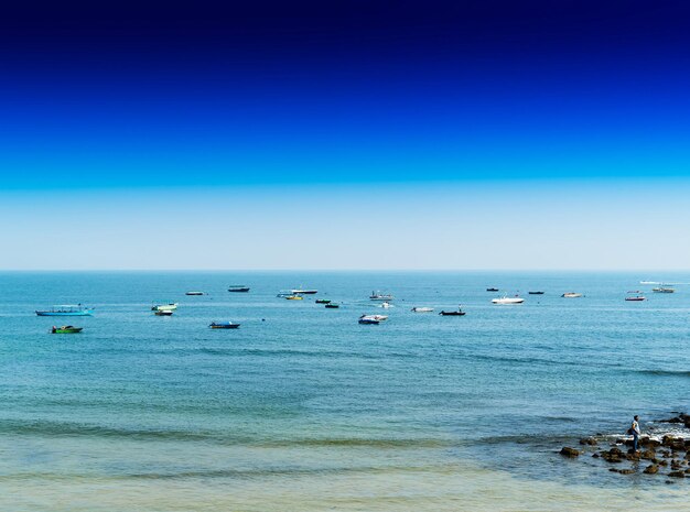 Barcos indios vivos horizontales en el fondo del horizonte oceánico