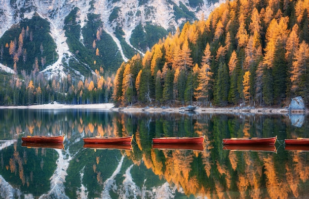 Barcos de madera en el lago Braies al amanecer en otoño