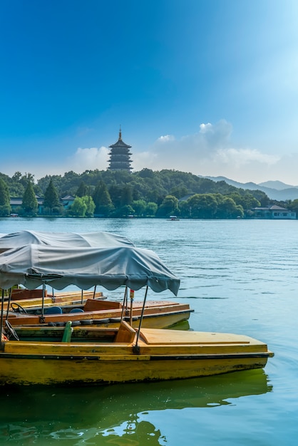 Barcos de madera y la pagoda Leifeng atracados en el lago del oeste de Hangzhou