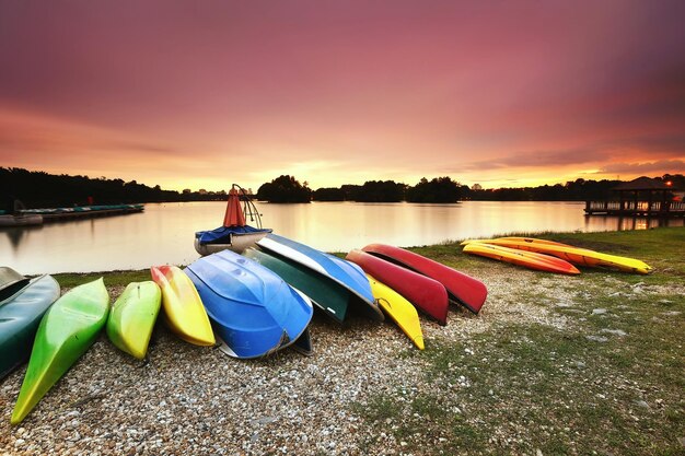 Barcos multicolores en el lago contra el cielo durante la puesta de sol