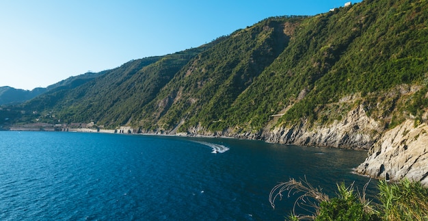Barcos na água azul perto da beira-mar no parque nacional de Cinque Terre na Itália