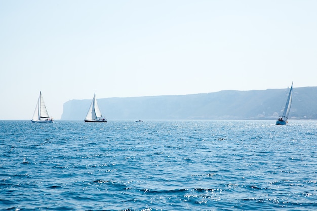 Los barcos navegan regata con veleros en mediterráneo.