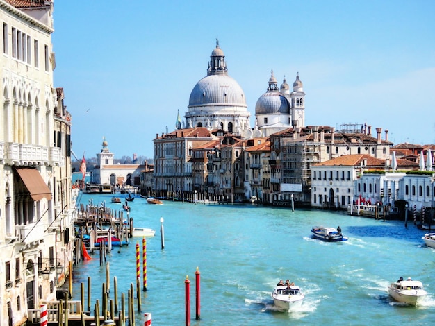 Foto barcos no grande canal com santa maria della saudação contra o céu