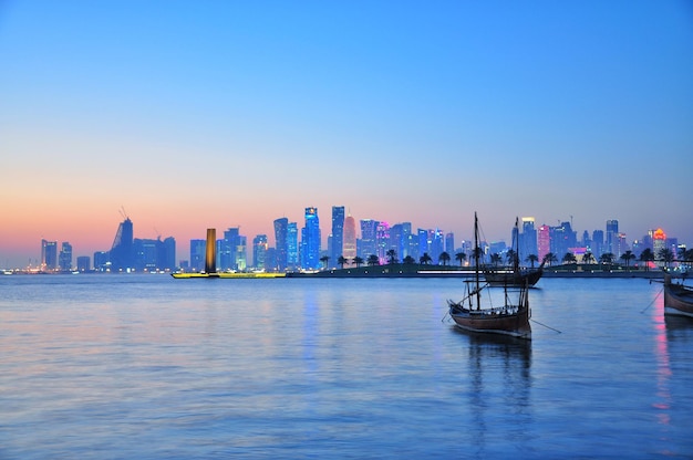Barcos no mar contra edifícios modernos ao pôr-do-sol