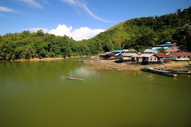 Barcos no rio com casas ao fundo