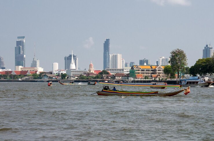 Foto barcos no rio por edifícios na cidade contra o céu