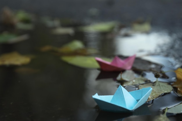 Barcos de papel en un charco al aire libre cuando llueve