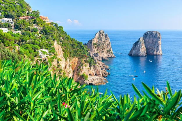 Barcos perto de penhascos de faraglioni e mar tirreno na ilha de capri, itália