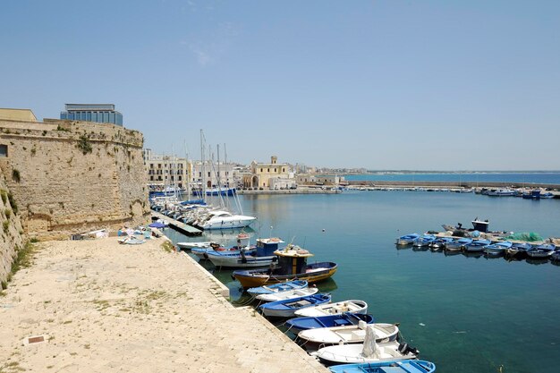 Barcos de pesca amarrados a muelles en la Ciudad Vieja cerca del castillo Gallipoli Provincia de Lecce Apulia Italia